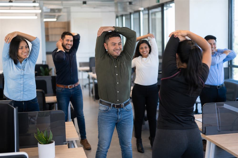 Colaboradores haciendo estiramientos y pausas activas en la oficina
