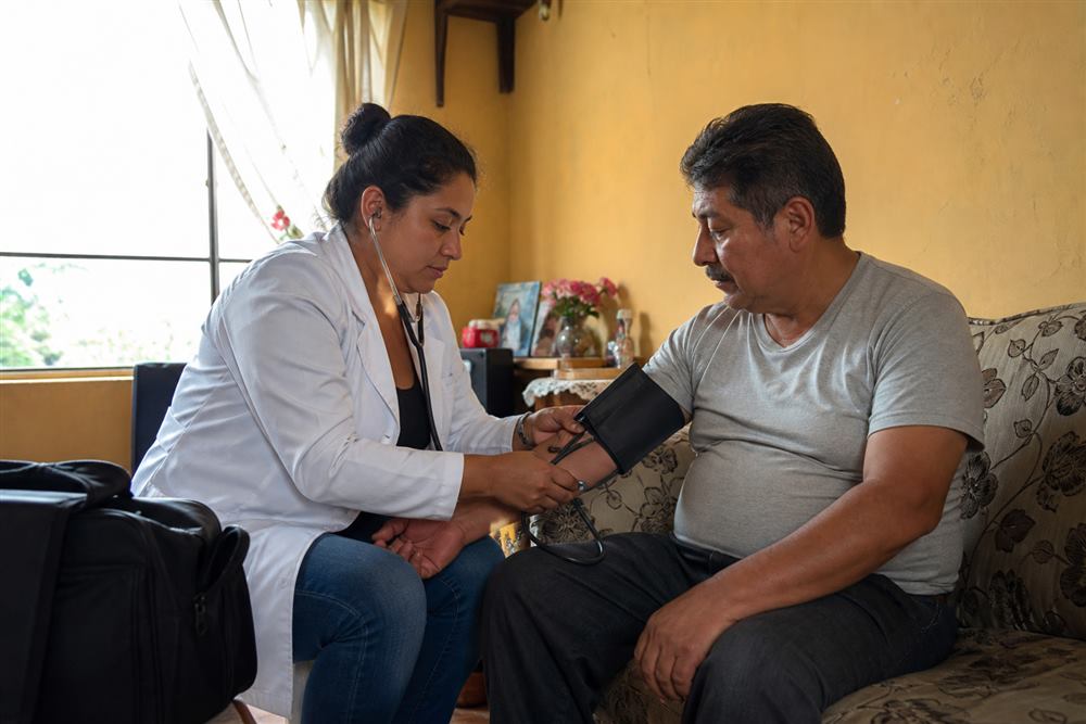 Médica atendiendo a paciente en visita médica a domicilio